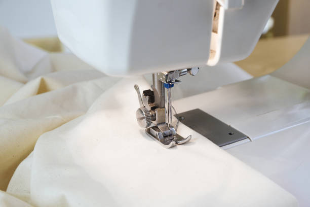 istock sewing machine with white fabric under the needle and the presser foot, close up 978367646