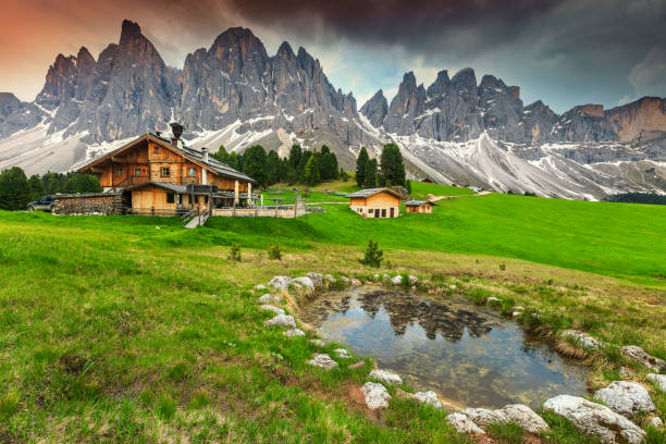 захватывающие альпийские шале с горным озером в доломитовых альпах, италия, европа - mountain snow sunset house стоковые фото и изображения