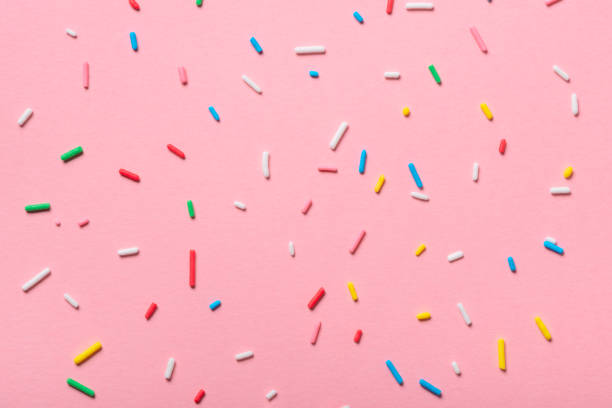 istock colorful sprinkles over pink background, decoration for cake and bakery 978374492