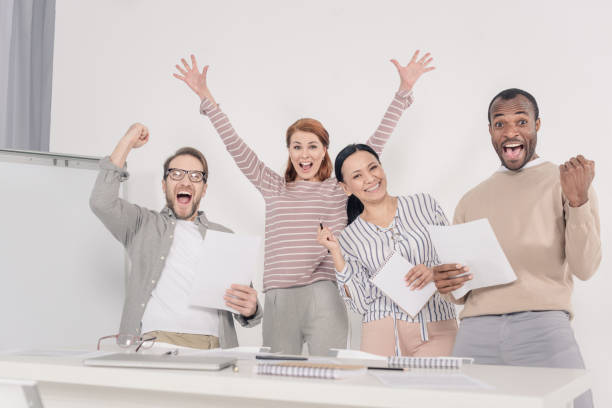 istock excited multiethnic middle aged people holding papers and triumphing 978375416