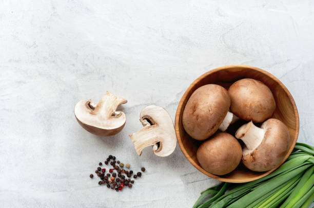 istock Sliced brown champignons on concrete background. Top view. 978375760