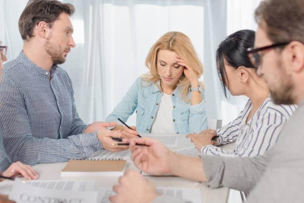 istock middle aged people signing contract at anonymous group therapy 978379528