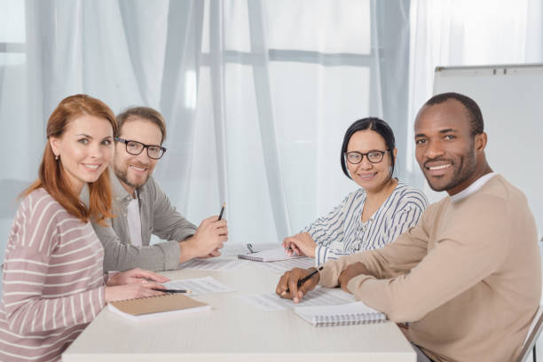 istock multiethnic middle aged business people smiling at camera while working together 978379840