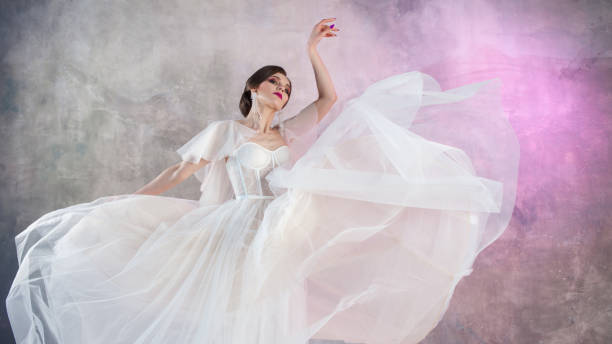 istock Beautiful and stylish bride in wedding dress in Studio on grey textured background 978382496