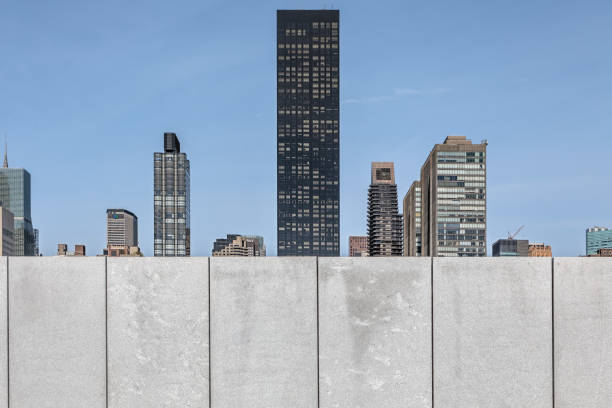 Roosevelt Island, New York, USA – May 2, 2018: A view across the Hudson River to the Manhattan skyline over a grey concrete wall