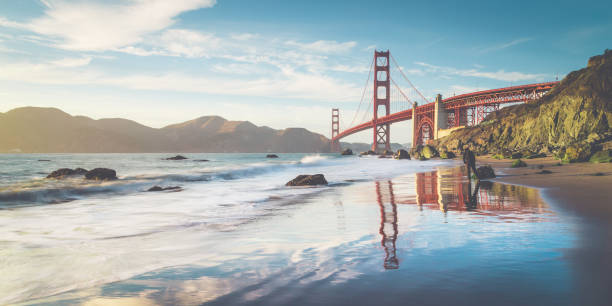 Golden Gate Bridge at sunset, San Francisco, California, USA Classic panoramic view of famous Golden Gate Bridge seen from scenic Baker Beach in beautiful golden evening light on a sunny day with blue sky and clouds in summer, San Francisco, California, USA baker beach stock pictures, royalty-free photos & images