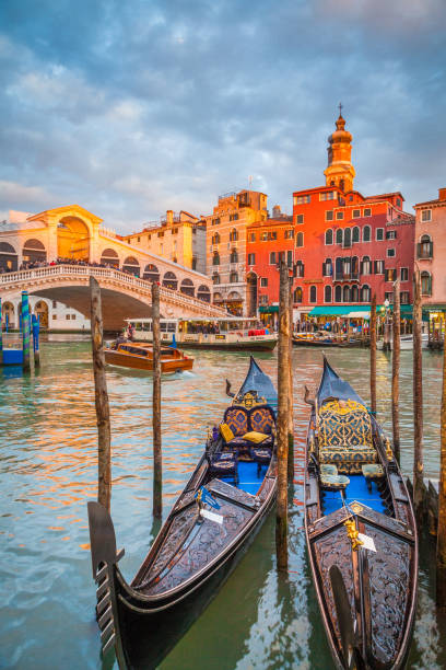 Canal Grande with Gondolas and Rialto Bridge at sunset, Venice, Italy Classic panoramic view with traditional Gondolas on famous Canal Grande with famous Rialto Bridge in the background in beautiful golden evening light at sunset in summer, Venice, Italy gondola traditional boat photos stock pictures, royalty-free photos & images