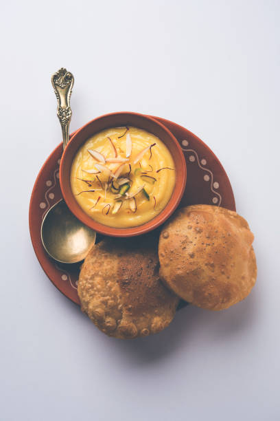 istock Shrikhand with fried Puri / Poori served in a bowl and plate over moody background. Selective focus 978405602