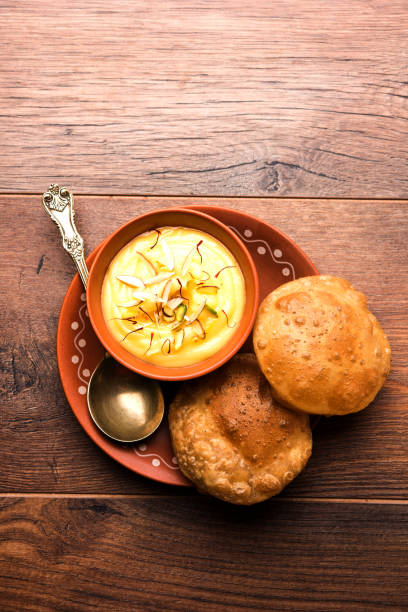 istock Shrikhand with fried Puri / Poori served in a bowl and plate over moody background. Selective focus 978405626