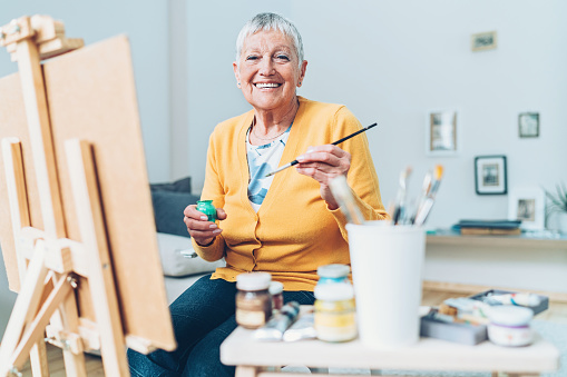 Senior artist woman drawing at home