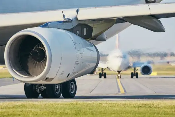 Hot air from jet engine against airplane taxiing to airport runway.