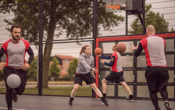 istock Female trainer coaching a basketball team during a street ball training session 978432712