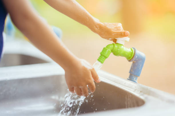istock Open water tap cleaning hand on sink on blurry background 978444492