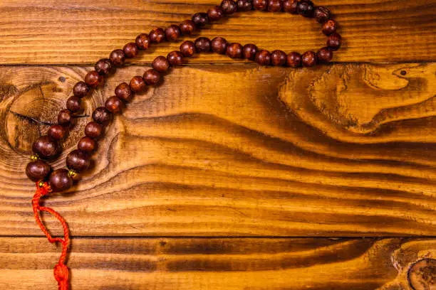 Photo of Brown rosary on the wooden table. Top view