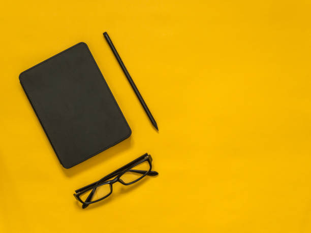 istock Flat lay black business accessories on yellow background with blank space for text. Top view. Copy space. 978469290