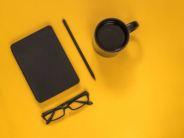 istock Flat lay black business accessories on yellow background with blank space for text. Top view. Copy space. 978469302