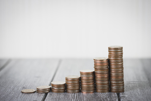 Coin stack step up growing growth saving money on wooden table and white background. Saving money, Business investment financial plan, With copy space for your text