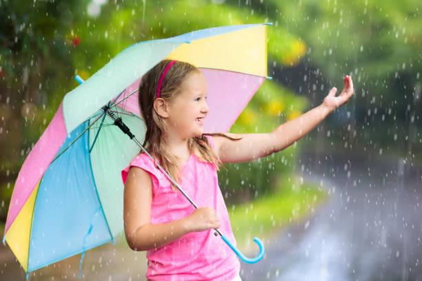 istock Kid with umbrella playing in summer rain. 978486898