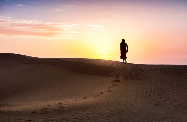 istock Woman in the desert with sunset view 978491074