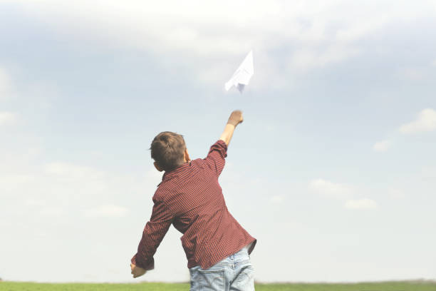 istock freedom concept with little boy throwing a paper plane in the sky 978498990
