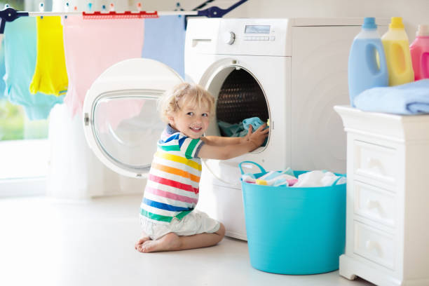 istock Child in laundry room with washing machine 978506294
