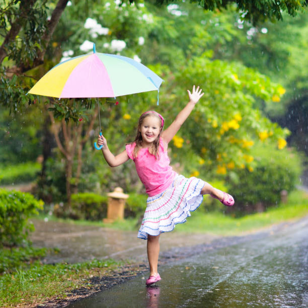 istock Kid with umbrella playing in summer rain. 978506692