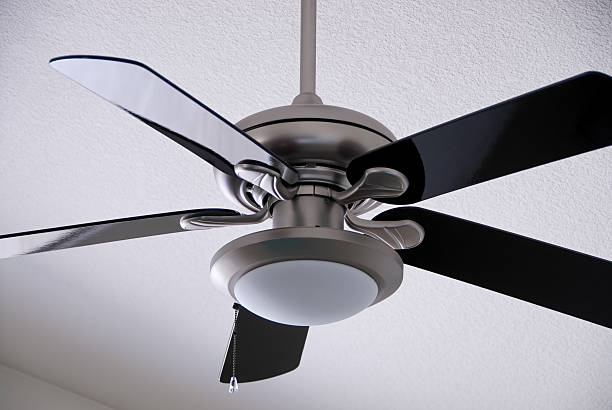 Brushed Metal Ceiling Fan A brushed metal ceiling fan with black fins. ceiling fan stock pictures, royalty-free photos & images