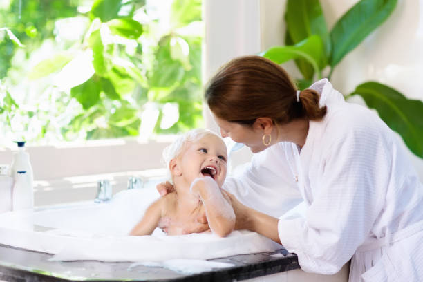 mutter baby waschen im schaumbad. spaß im wasser. - ein bad nehmen stock-fotos und bilder