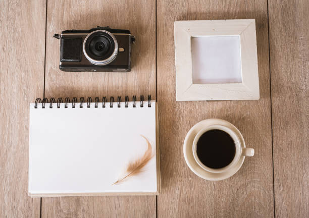 istock Blank Notebook and picture frame Camera, Coffee on Wood Board. 978510936