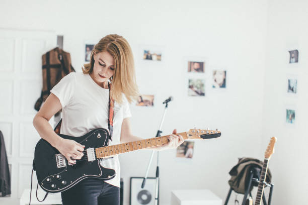 istock Young woman playing guitar in studio 978513714