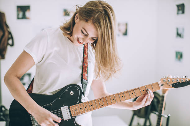 istock Young woman playing guitar 978516022