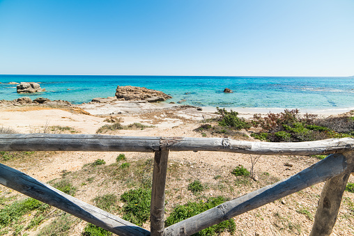 Wooden fence by the sea in Santa Giusta shore. Sardinia, Italy