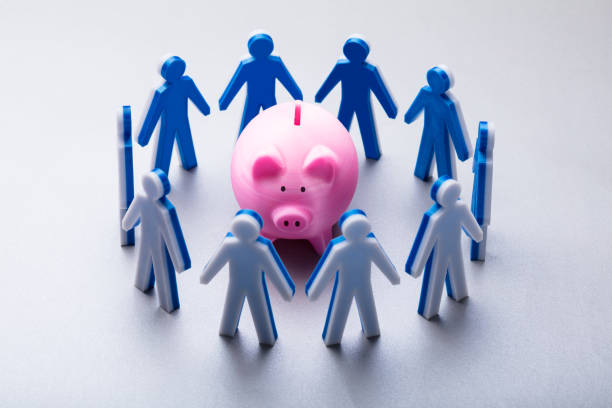 istock Human Figures Surrounding Pink Piggybank 978520436