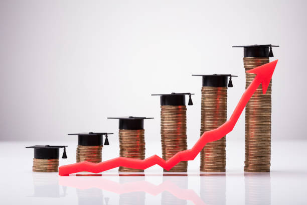 istock Increasing Red Arrow In Front Of Coins With Graduation Hat 978520774