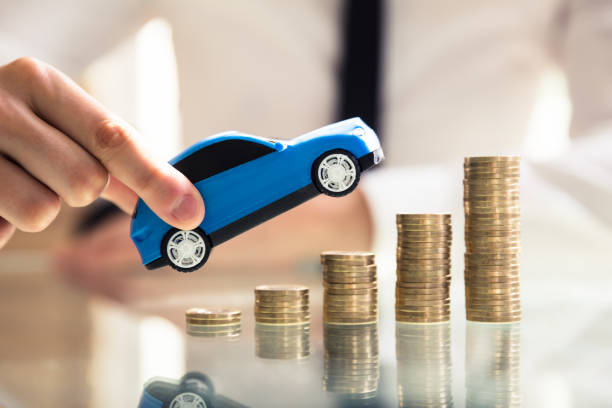 istock Person Holding Car Over Rising Stacked Coins 978523140