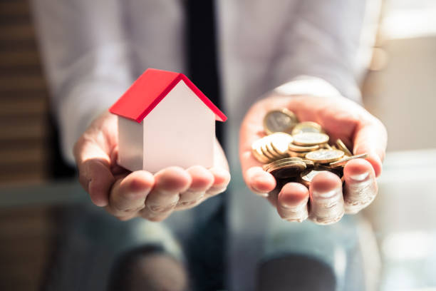 Businessperson Holding House Model And Golden Coins Close-up Of A Businessperson's Hand Holding House Model And Golden Coins money house stock pictures, royalty-free photos & images