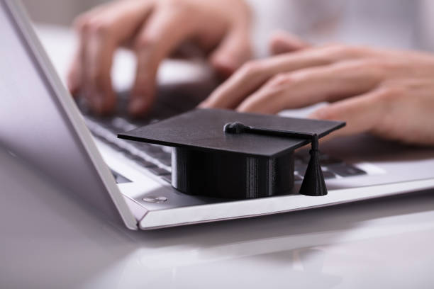 istock Black Graduation Hat On Laptop Keypad 978525320