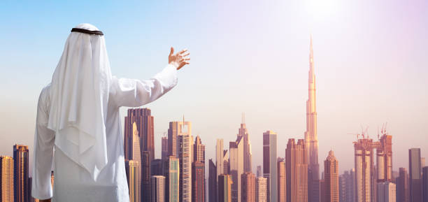istock Man Outstretching His Hand At Modern Buildings In Dubai 978525568