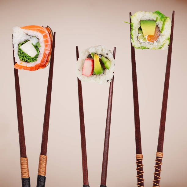 istock Traditional japanese sushi pieces placed between chopsticks on pastel color background 978525900