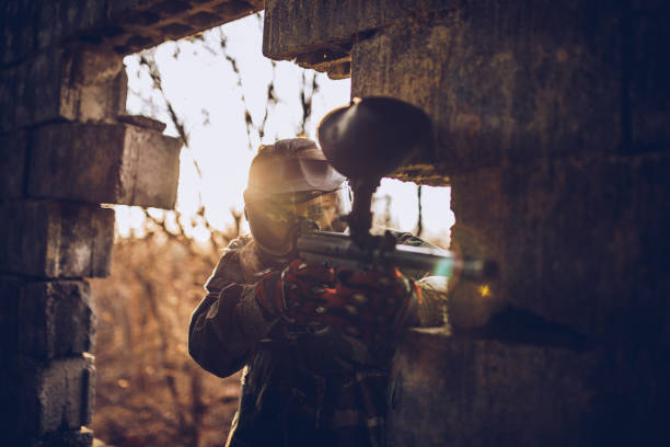 istock Woman paintball player shooting a weapon 978526124