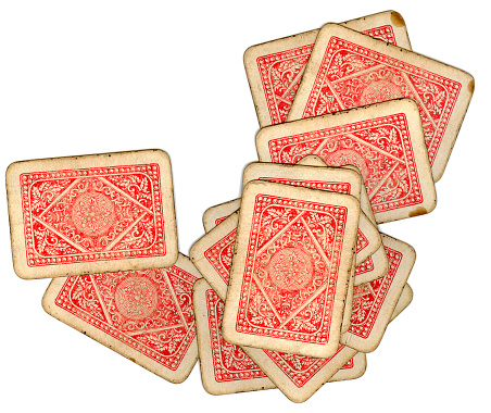 A scattered deck of antique playing cards