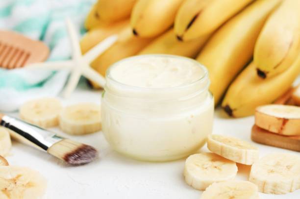 Homemade banana skincare beauty treatment mask. Jar of aromatic body butter,  fresh ripe yellow fruit preparing yummy skin product. Soft focus. mash food state stock pictures, royalty-free photos & images