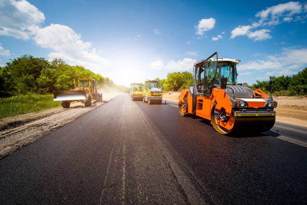 paisaje industrial con rodillos que rueda un nuevo asfalto en el camino. reparación, movimiento de transporte complicado. - paving stone fotos fotografías e imágenes de stock