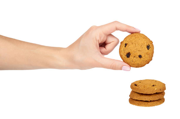 istock Home made oragnic chocolate chips cookies with raisins in hand. Isolated on white background 978545608