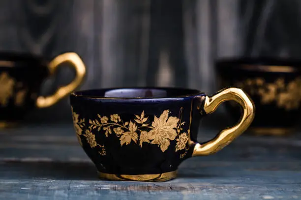 Ceramic Turkish coffee mugs on blue wooden background