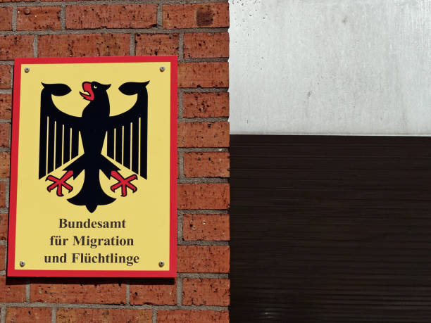 Federal Office for Migration and Refugees - Official Sign Official sign of the Federal Office for Migration and Refugees on a red brick wall/ Bundesamt für Migration und Flüchtlinge in Fuerth, Germany on a sunny day. Detail of Entrance aera. fuerth stock pictures, royalty-free photos & images