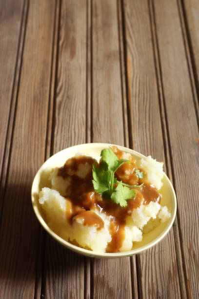 istock Bowl of Mashed Potatoes and Gravy against Rustic Wood Background 978575562