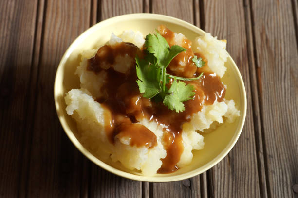 istock Bowl of Mashed Potatoes and Gravy against Rustic Wood Background 978575564