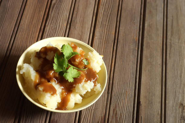 istock Bowl of Mashed Potatoes and Gravy against Rustic Wood Background 978575580