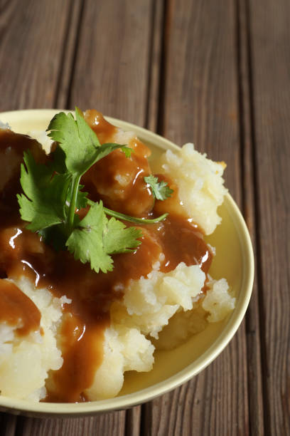 istock Bowl of Mashed Potatoes and Gravy against Rustic Wood Background 978575594